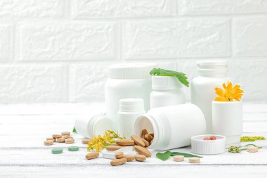 Bitki bazlı takviyeler, taze otlar ve çiçeklerle birlikte doğal vitaminler. Organik maddeler, bütünsel sağlık kavramlarını, alternatif yaşam tarzını öneriyor. Beyaz arkaplan, alanı kopyala
