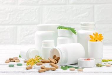 Bitki bazlı takviyeler, taze otlar ve çiçeklerle birlikte doğal vitaminler. Organik maddeler, bütünsel sağlık kavramlarını, alternatif yaşam tarzını öneriyor. Beyaz arkaplan, alanı kopyala