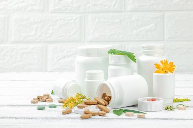 Bitki bazlı takviyeler, taze otlar ve çiçeklerle birlikte doğal vitaminler. Organik maddeler, bütünsel sağlık kavramlarını, alternatif yaşam tarzını öneriyor. Beyaz arkaplan, alanı kopyala