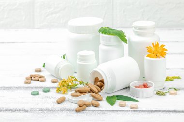 Bitki bazlı takviyeler, taze otlar ve çiçeklerle birlikte doğal vitaminler. Organik maddeler, bütünsel sağlık kavramlarını, alternatif yaşam tarzını öneriyor. Beyaz arkaplan, kapat