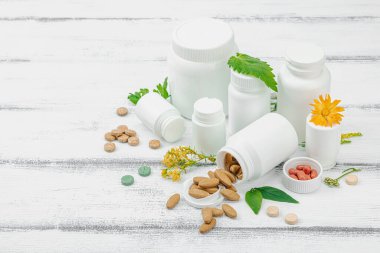 Bitki bazlı takviyeler, taze otlar ve çiçeklerle birlikte doğal vitaminler. Organik maddeler, bütünsel sağlık kavramlarını, alternatif yaşam tarzını öneriyor. Beyaz arkaplan, alanı kopyala