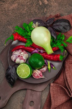 Sıcak kahverengi tonlarda yemek pişirme. Taze sebze ve bitkiler, baharat hazırlama süreci. Vejetaryen tarifi, sağlıklı yaşam tarzı, geleneksel Hint mutfağı. Taş arkaplan, üst görünüm