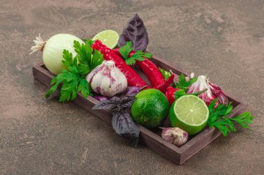 Sıcak kahverengi tonlarda yemek pişirme. Taze sebze ve bitkiler, baharat hazırlama süreci. Vejetaryen tarifi, sağlıklı yaşam tarzı, geleneksel Hint mutfağı. Taş arkaplan, kopyalama alanı