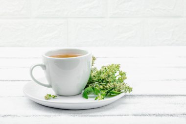 Beyaz ahşap arka planda limonlu çay. Yenilebilir taze otlar, modaya uygun içecekler. Organik sağlık, eko yaşam tarzı, vegan içecek, kopyalama alanı