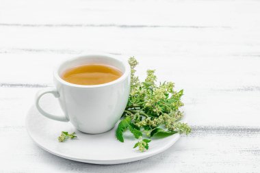 Beyaz ahşap arka planda limonlu çay. Yenilebilir taze otlar, modaya uygun içecekler. Organik sağlık, eko yaşam tarzı, vegan içecek, kopyalama alanı