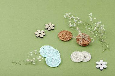 Crochet face scrubby cotton pads. Handmade reusable accessories for eco beauty routine. Zero waste useful concept, trendy green background, flat lay, copy space clipart