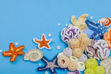 Yaz tığ işi konsepti. El yapımı mercan resifi, deniz tarzı, sualtı hayvanları. Deniz mavisi arkaplan, düz yatış, kopyalama alanı