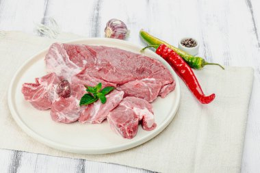 Çiğ domuz eti. Yemek pişirmek için geleneksel malzemeler. Sarımsaklı karanfil, taze fesleğen ve acı biber. Moda mutfak konsepti, beyaz arka plan, düz yatak, yakın çekim