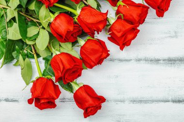 Beyaz arka planda bir buket kırmızı gül. Çiçek açan, Anneler Günü ya da Sevgililer Günü için neşeli bir konsept. Tebrik kartı, Paskalya düzlüğü, en iyi dilekler, en iyi manzara.