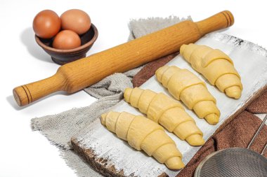 Donmuş kruvasanlar, geleneksel tatlı yapma süreci. Rahatlatıcı yemekler, klasik kahvaltı. Modaya uygun sert ışık, koyu gölge, beyaz arkaplan, kapat