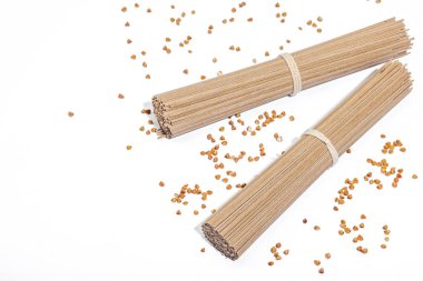 Japanese buckwheat soba noodles. Classic ingredient for preparing traditional dishes. Hard light, dark shadow, white background, copy space clipart