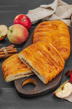 Sonbahar elmalı turtası. Ev yapımı pişirme, tatlı tatlı, olgun meyve ve tarçın. Rahatlatıcı gıda konsepti, siyah ahşap arka plan, düz yatak, yakın çekim