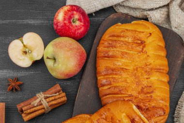 Sonbahar elmalı turtası. Ev yapımı pişirme, tatlı tatlı, olgun meyve ve tarçın. Rahat yiyecek konsepti, siyah ahşap arka plan, düz yatak, üst manzara