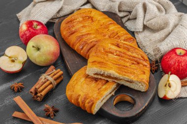 Sonbahar elmalı turtası. Ev yapımı pişirme, tatlı tatlı, olgun meyve ve tarçın. Rahatlatıcı gıda konsepti, siyah ahşap arka plan, düz yatak, yakın çekim