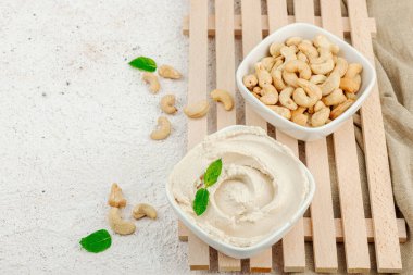 Ev yapımı vejetaryen kaju peyniri. Tabakta çiğ sağlıklı sos, laktozsuz yemek. Biyolojik organik ürün, bitki temelli diyet, alternatif yaşam tarzı. Işık taşı arkaplanı, boşluğu kopyala