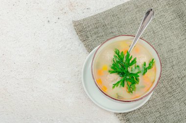 Yeşillik ve köfteli ev yapımı İtalyan düğün çorbası. Tavuk ve fasulyeli sebze çorbası, rahatlatıcı yemek. Hafif alçı arkaplan, üst görünüm