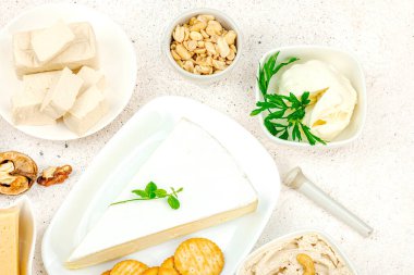 Çeşitli ev yapımı vejetaryen fındık peyniri seti. Tabakta çiğ sağlıklı sos, laktozsuz yemek. Biyolojik organik ürün, bitki temelli diyet, alternatif yaşam tarzı. Işık taşı arkaplan, üst görünüm