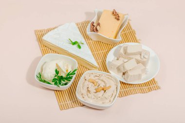 Çeşitli ev yapımı vejetaryen fındık peyniri seti. Tabakta çiğ sağlıklı sos, laktozsuz yemek. Biyolojik organik ürün, bitki temelli diyet, alternatif yaşam tarzı. Şeftali arkaplanı, boşluğu kopyala