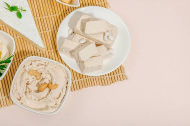 Çeşitli ev yapımı vejetaryen fındık peyniri seti. Tabakta çiğ sağlıklı sos, laktozsuz yemek. Biyolojik organik ürün, bitki temelli diyet, alternatif yaşam tarzı. Şeftali arkaplan, üst görünüm