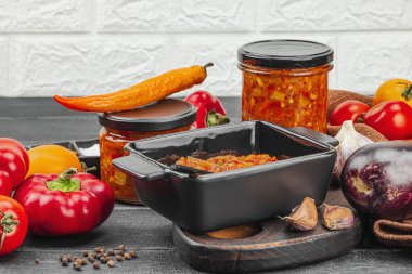 Sebze havyarı, geleneksel vejetaryen yahnisi, sote. Olgun sebzeler, mis kokulu baharatlar, yiyecek konseptini muhafaza etmek. Rahat ve nostaljik ruh hali, siyah ahşap arka plan, kopyalama alanı