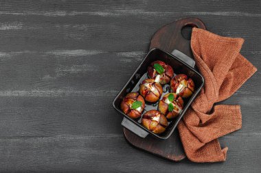 Peynirli peynirli, otlu ve ballı fırında incir. Sağlıklı yiyecekler, mevsimlik meyveler, lezzetli atıştırmalıklar. Siyah ahşap arkaplan, üst manzara