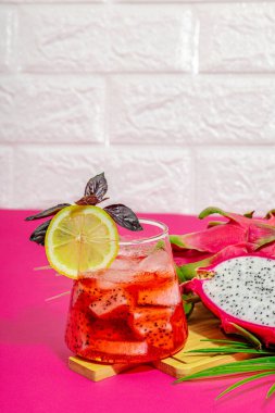 Ejderha meyveli içecek. Pitaya tropik içeceği, smoothie, kokteyl. Tatlı limonata, limonlu mojito ve fesleğen. Pembe arkaplan, kopyalama alanı