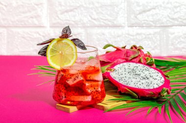 Ejderha meyveli içecek. Pitaya tropik içeceği, smoothie, kokteyl. Tatlı limonata, limonlu mojito ve fesleğen. Pembe arkaplan, kopyalama alanı