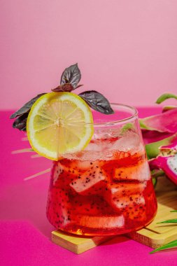 Ejderha meyveli içecek. Pitaya tropik içeceği, smoothie, kokteyl. Tatlı limonata, limonlu mojito ve fesleğen. Pembe arkaplan, kopyalama alanı