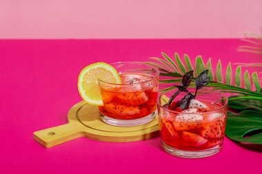 Ejderha meyveli içecek. Pitaya tropik içeceği, smoothie, kokteyl. Tatlı limonata, limonlu mojito ve fesleğen. Pembe arkaplan, kopyalama alanı