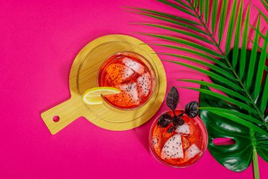 Ejderha meyveli içecek. Pitaya tropik içeceği, smoothie, kokteyl. Tatlı limonata, limonlu mojito ve fesleğen. Pembe arkaplan, üst görünüm