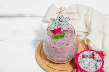 Pitaya smoothie, sağlıklı detoks içeceği. Moda içecek, yararlı kahvaltı fikri. Sert ışık, karanlık gölge, beyaz ahşap zemin, kopyalama alanı