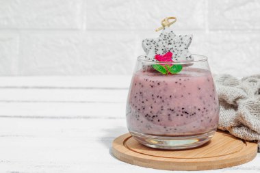 Pitaya smoothie, sağlıklı detoks içeceği. Moda içecek, yararlı kahvaltı fikri. Sert ışık, karanlık gölge, beyaz ahşap zemin, kopyalama alanı