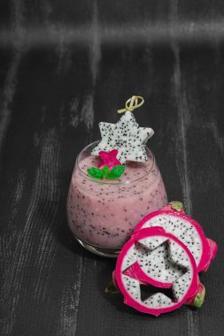 Pitaya smoothie, sağlıklı detoks içeceği. Moda içecek, yararlı kahvaltı fikri. Sert ışık, karanlık gölge, siyah ahşap zemin, kopyalama alanı
