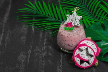 Pitaya smoothie, sağlıklı detoks içeceği. Moda içecek, yararlı kahvaltı fikri. Sert ışık, karanlık gölge, siyah ahşap zemin, kopyalama alanı