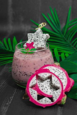 Pitaya smoothie, sağlıklı detoks içeceği. Moda içecek, yararlı kahvaltı fikri. Sert ışık, karanlık gölge, siyah ahşap arka plan, kapat