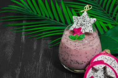 Pitaya smoothie, sağlıklı detoks içeceği. Moda içecek, yararlı kahvaltı fikri. Sert ışık, karanlık gölge, siyah ahşap zemin, kopyalama alanı