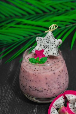 Pitaya smoothie, sağlıklı detoks içeceği. Moda içecek, yararlı kahvaltı fikri. Sert ışık, karanlık gölge, siyah ahşap arka plan, kapat