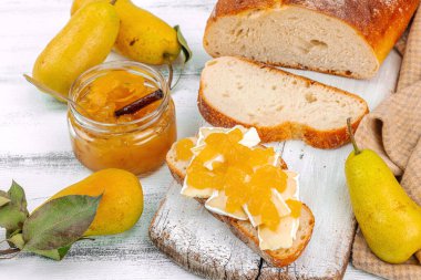 Ev yapımı armut reçeli, ziyafet, marmelat, peynirli açık sandviç. Tatlı tatlı, yiyecekleri muhafaza et. Olgun çiftlik meyveleri, lezzetli saklama. Beyaz ahşap arka plan, kapat