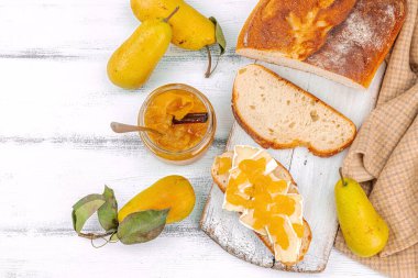 Ev yapımı armut reçeli, ziyafet, marmelat, peynirli açık sandviç. Tatlı tatlı, yiyecekleri muhafaza et. Olgun çiftlik meyveleri, lezzetli saklama. Beyaz ahşap arkaplan, üst görünüm
