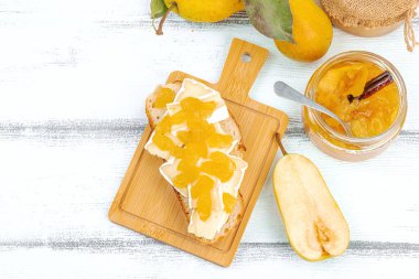 Ev yapımı armut reçeli, ziyafet, marmelat, peynirli açık sandviç. Tatlı tatlı, yiyecekleri muhafaza et. Olgun çiftlik meyveleri, lezzetli saklama. Beyaz ahşap arkaplan, üst görünüm