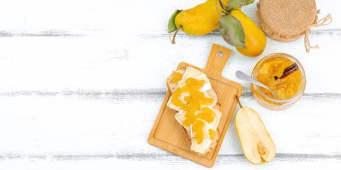 Ev yapımı armut reçeli, ziyafet, marmelat, peynirli açık sandviç. Tatlı tatlı, yiyecekleri muhafaza et. Olgun çiftlik meyveleri, lezzetli saklama. Beyaz ahşap arkaplan, pankart biçimi