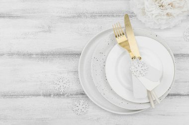 Noel sofrası. Yeni yıl çatal bıçak takımı, geleneksel kış dekorasyonu, düz yatak. Keyifli bir ortam, minimalist tasarım. Sert ışık, karanlık gölge, beyaz ahşap zemin, üst manzara