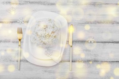 Noel sofrası. Yeni yıl çatal bıçak takımı, geleneksel kış dekorasyonu, düz yatak. Keyifli bir ortam, minimalist tasarım. Sert ışık, karanlık gölge, beyaz ahşap zemin, üst manzara