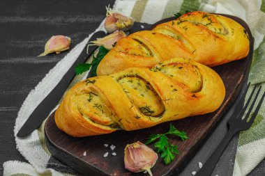 Fresh baked garlic bread, gluten free buns. Tasty food, fresh parsley, fragrant spices. Homemade bakery, ingredient for preparation toasts. Black wooden boards, close up clipart