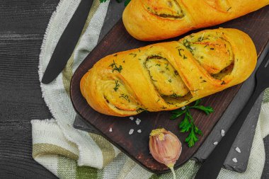 Taze sarımsaklı ekmek, glütensiz çörek. Lezzetli yemekler, taze maydanoz, mis kokulu baharatlar. Ev yapımı fırın, hazırlık tostları için malzeme. Siyah ahşap tahtalar, üst manzara.