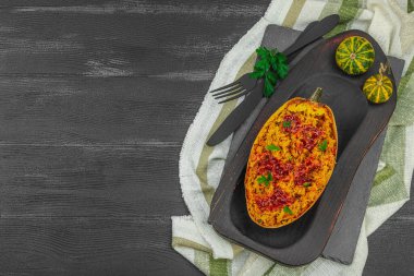 Baked spaghetti squash with spices, herbs and tomato sauce. Gluten free food, healthy dinner, vegan lifestyle. Ready to eat, served portion. Black wooden background, top view clipart