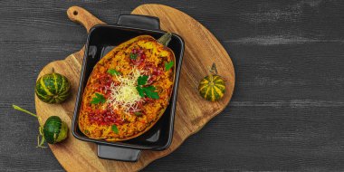 Baked spaghetti squash with spices, herbs and tomato sauce. Gluten free food, healthy dinner, vegan lifestyle. Ready to eat, served portion. Black wooden background, banner format clipart