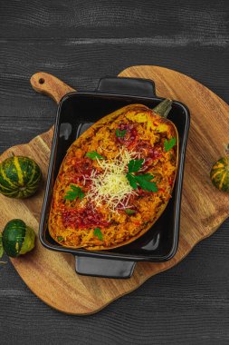 Baked spaghetti squash with spices, herbs and tomato sauce. Gluten free food, healthy dinner, vegan lifestyle. Ready to eat, served portion. Black wooden background, top view clipart