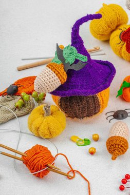 Set of clew of thread for knitting Halloween decoration. Crocheted different houses, handmade, autumn hobby concept. Props and special craft tools on light stone background, close up