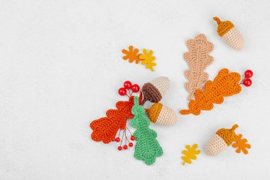 Geleneksel sonbahar süslemeleri. Farklı meşe palamudu ve yapraklar örülmüş, el yapımı, samimi bir hobi. Işık taşı arkaplan üzerine sonbahar dekorları, üst görünüm